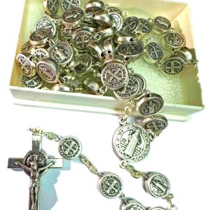 Rosario metálico con medallas de San Benito y crucifijo sobre superficie blanca