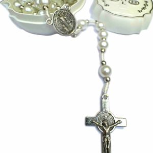 Rosario de perlas con medalla de San Benito sobre superficie blanca